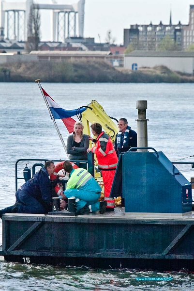 10040809.jpg - FOTOOPDRACHT:Papendrecht:08-04-2010:Foto: De beide slachtoffers (vrouw staand en man liggend op dek)worden verzorg, en naar de wal gebracht nadat hun speedbootje over varen is. AANVARING TUSSEN BINNENVAARTSCHIP EN TANKER PAPENDRECHT  Bij een aanvaring tussen een lege binnenvaarttanker en een pleziervaartuig op 8 april rond 14.15 uur op de rivier de Beneden Merwede bij Papendrecht zijn twee opvarenden van het pleziervaartuig te water geraakt. Het gaat om een 60-jarige man uit Dordrecht en een 26-jarige plaatsgenote. Beiden zijn met onderkoelingsverschijnselen voor controle naar een ziekenhuis overgebracht. Hoe de aanvaring heeft kunnen plaatsvinden is nog niet geheel duidelijk. Het onderzoek ligt in handen van de Waterpolitie, onderdeel van het Korps Landelijke Politiediensten. Wel is duidelijk dat twee opvarenden te water raakten. Mensen van een ander binnenvaartschip en personeel van Rijkswaterstaat konden hen net op tijd uit het water halen en naar de kant brengen. Daar stonden meerdere ambulances en een traumahelikopter klaar voor de medische hulp. De toestand van de slachtoffers lijkt mee te vallen. Doordat in de eerste minuten van het incident nog niet duidelijk was hoeveel mensen te water waren geraakt, is opgeschaald tot Grip 1 en waren de hulpdiensten in groten getale aanwezig. Al snel was duidelijk dat het aantal mensen dat in het water terecht was gekomen tot twee beperkt was gebleven en dat er niemand vermist was. Het pleziervaartuig raakte zwaar beschadigd en is door Rijkswaterstaat aangehaakt en naar de kant gebracht. De tanker bleef nagenoeg onbeschadigd en kon op eigen kracht naar de dichtstbijzijnde kade varen. Het scheepvaartverkeer werd niet gestremd Deze digitale foto blijft eigendom van FOTOPERSBURO BUSINK. Wij hanteren de voorwaarden van het N.V.F. en N.V.J. Gebruik van deze foto impliceert dat u bekend bent en akkoord gaat met deze voorwaarden bij publicatie. EB/ETIENNE BUSINK