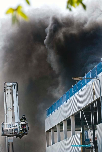 10041302.jpg - FOTOOPDRACHT:Dordrecht:13-04-2010:Bij een grote brand op het terrein van Arbeidsontwikkelingsbedrijf Drechtwerk aan de Kamerlingh Onnesweg 1 Dordrecht. BRAND OP DAK DORDRECHT  Door nog onbekende oorzaak heeft een plat dak van een in aanbouw zijnd pand aan de Kamerlingh Onnesweg op 13 april korte tijd in brand gestaan. Niemand raakte gewond. Op het dak waren werklui bezig geweest die ten tijdevan het ontstaan van de brand aan het schaften waren. Zij keerden snel terug en konden tijdig enkele gasflessen veilig stellen en daarmee erger voorkomen. De brandweer was er met onder meer een hoogwerker snel bij en had de brand in korte tijd geblust. Er was korte tijd sprake van een forse rookontwikkeling. Er zijn echter geen gevaarlijke stoffen vrijgekomen en geen van de bedrijven in de directe omgeving hoefde ontruimd te worden. Deze digitale foto blijft eigendom van FOTOPERSBURO BUSINK. Wij hanteren de voorwaarden van het N.V.F. en N.V.J. Gebruik van deze foto impliceert dat u bekend bent  en akkoord gaat met deze voorwaarden bij publicatie.EB/ETIENNE BUSINK