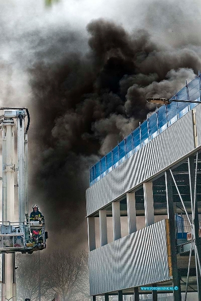 10041305.jpg - FOTOOPDRACHT:Dordrecht:13-04-2010:Bij een grote brand op het terrein van Arbeidsontwikkelingsbedrijf Drechtwerk aan de Kamerlingh Onnesweg 1 Dordrecht woede bij een in aanbouw zijnde loods een grote brand op het dak van het pand. De brand ging gepaard met grote dikke zwarte wolken en was toe in ver te zien. De brandweer zetten groot materieel in en had de brand na een uurtje redelijk onder controle over schade aan het nieuwe pand kon men nog niks zeggen.Deze digitale foto blijft eigendom van FOTOPERSBURO BUSINK. Wij hanteren de voorwaarden van het N.V.F. en N.V.J. Gebruik van deze foto impliceert dat u bekend bent  en akkoord gaat met deze voorwaarden bij publicatie.EB/ETIENNE BUSINK