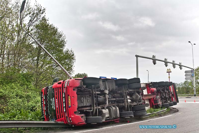 10050703.jpg - FOTOOPDRACHT:Dordrecht:07-05-2010:VRACHTWAGEN GEKANTELD DORDRECHT - Een vrachtwagencombinatie is op de N3 in Dordrecht bij de oprit naar de rijksweg A16 gekanteld. Het ongeval gebeurde op vrijdagmorgen 7 mei 2010. Het ging om een vrachtwagen met oplegger. Hierop stond een koelcontainer met daarin ongeveer 25 ton fruit. De 24-jarige chauffeur uit Alblasserdam zag kans zelf uit zijn cabine te kruipen. Wel plaatste de brandweer een trap zodat de bestuurder naar beneden kon. Hij had een lichte hoofdwond. Mogelijk reed de vrachtwagencombinatie te snel in de bocht waardoor het voertuig kantelde.Deze digitale foto blijft eigendom van FOTOPERSBURO BUSINK. Wij hanteren de voorwaarden van het N.V.F. en N.V.J. Gebruik van deze foto impliceert dat u bekend bent  en akkoord gaat met deze voorwaarden bij publicatie.EB/ETIENNE BUSINK