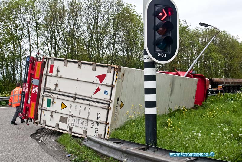 10050704.jpg - FOTOOPDRACHT:Dordrecht:07-05-2010:VRACHTWAGEN GEKANTELD DORDRECHT - Een vrachtwagencombinatie is op de N3 in Dordrecht bij de oprit naar de rijksweg A16 gekanteld. Het ongeval gebeurde op vrijdagmorgen 7 mei 2010. Het ging om een vrachtwagen met oplegger. Hierop stond een koelcontainer met daarin ongeveer 25 ton fruit. De 24-jarige chauffeur uit Alblasserdam zag kans zelf uit zijn cabine te kruipen. Wel plaatste de brandweer een trap zodat de bestuurder naar beneden kon. Hij had een lichte hoofdwond. Mogelijk reed de vrachtwagencombinatie te snel in de bocht waardoor het voertuig kantelde.Deze digitale foto blijft eigendom van FOTOPERSBURO BUSINK. Wij hanteren de voorwaarden van het N.V.F. en N.V.J. Gebruik van deze foto impliceert dat u bekend bent  en akkoord gaat met deze voorwaarden bij publicatie.EB/ETIENNE BUSINK