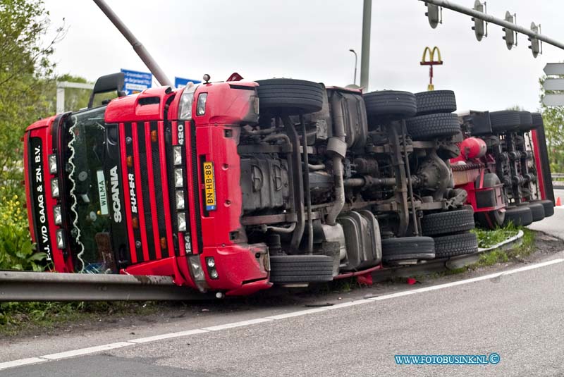 10050705.jpg - FOTOOPDRACHT:Dordrecht:07-05-2010:VRACHTWAGEN GEKANTELD DORDRECHT - Een vrachtwagencombinatie is op de N3 in Dordrecht bij de oprit naar de rijksweg A16 gekanteld. Het ongeval gebeurde op vrijdagmorgen 7 mei 2010. Het ging om een vrachtwagen met oplegger. Hierop stond een koelcontainer met daarin ongeveer 25 ton fruit. De 24-jarige chauffeur uit Alblasserdam zag kans zelf uit zijn cabine te kruipen. Wel plaatste de brandweer een trap zodat de bestuurder naar beneden kon. Hij had een lichte hoofdwond. Mogelijk reed de vrachtwagencombinatie te snel in de bocht waardoor het voertuig kantelde.Deze digitale foto blijft eigendom van FOTOPERSBURO BUSINK. Wij hanteren de voorwaarden van het N.V.F. en N.V.J. Gebruik van deze foto impliceert dat u bekend bent  en akkoord gaat met deze voorwaarden bij publicatie.EB/ETIENNE BUSINK