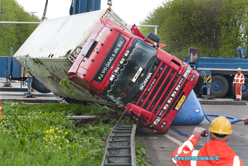 10050706.jpg - FOTOOPDRACHT:Dordrecht:07-05-2010:Foto: Het Bergen van de gekantelde Vrachtwagen. VRACHTWAGEN GEKANTELDDORDRECHT - Een vrachtwagencombinatie is op de N3 in Dordrecht bij de oprit naar de rijksweg A16 gekanteld. Het ongeval gebeurde op vrijdagmorgen 7 mei 2010. Het ging om een vrachtwagen met oplegger. Hierop stond een koelcontainer met daarin ongeveer 25 ton fruit. De 24-jarige chauffeur uit Alblasserdam zag kans zelf uit zijn cabine te kruipen. Wel plaatste de brandweer een trap zodat de bestuurder naar beneden kon. Hij had een lichte hoofdwond. Mogelijk reed de vrachtwagencombinatie te snel in de bocht waardoor het voertuig kanteldeDeze digitale foto blijft eigendom van FOTOPERSBURO BUSINK. Wij hanteren de voorwaarden van het N.V.F. en N.V.J. Gebruik van deze foto impliceert dat u bekend bent  en akkoord gaat met deze voorwaarden bij publicatie.EB/ETIENNE BUSINK