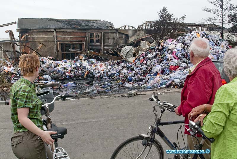 10061313.jpg - FOTOOPDRACHT:Dordrecht:13-06-2010:Dag na de Zeer grote brand bij Gebotex kilkade 23 Dordrecht, het bedrijf importeur/grossiers van bruikbare kleding recyclingZEER GROTE BRAND BIJ KLEDINGRECYCLEBEDRIJFDORDRECHT - In de nacht van zaterdag op zondag 13 juni heeft een zeer grote brand gewoed bij een kledingrecylcebedrijf. Rond 1.15 uur kwam de melding dat er band was uitgebroken in het bedrijf aan de Kilkade. Hierop rukten diverse brandweervoertuigen uit. Kort na het ontstaan van de brand schaalde de brandweer op naar zeer grote brand en werd vanwege de omvang van de brand besloten over te gaan tot GRIP 1 (Gecoördineerde Regionale Incidentenbestrijding Procedure). Diverse brandweerkorpsen uit de regio kwamen met groot materieel ter plaatse om de brand te bestrijden en te voorkomen dat de brand oversloeg naar de rest van het bedrijf. Uit voorzorg kwam ook een blusboot ter plaatse om eventueel vanaf het water aan de achterzijde van het pand bluswerkzaamheden te verrichten. Dit bleek uiteindelijk niet nodig. De brandweer is de hele nacht met man en macht bezig geweest het vuur te  bestrijden. Om 6.00 uur kon het sein brandmeester worden gegeven.Als gevolg van de brand werden twee hallen van het bedrijf in as gelegd. De brandweer wist te voorkomen dat de brand oversloeg naar een derde hal achter de twee uitgebrandde hallen. Wel ontstond er schade aan de gevel van de derde hal door de hitte van de brand. Twee naastgelegen panden van hetzelfde bedrijf bleven gespaard. Bij de brand vielen geen slachtoffers. Als gevolg van de brand was er sprake van een forse rookontwikkeling. De rook trok weg in de richting van de wijk Sterrenburg en zorgde ervoor dat op sommige plekken roetdeeltjes neersloegen. De brandweer verrichtte diverse metingen. Hieruit bleek dat er geen gevaarlijke stoffen zijn vrij gekomen en dat de brand geen gevaar opleverde voor de omgeving.De oorzaak van de brand is niet bekend. De Politie Zuid-Holland-Zuid stelt hiernaar een onderzoek in. De brandweer verw