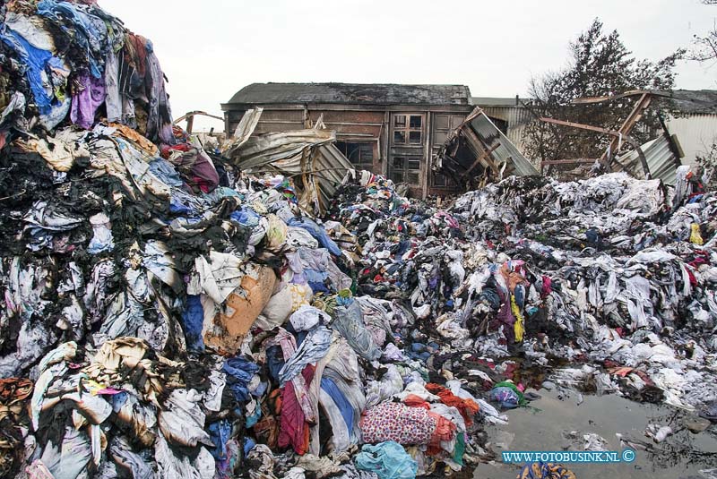 10061316.jpg - FOTOOPDRACHT:Dordrecht:13-06-2010:Dag na de Zeer grote brand bij Gebotex kilkade 23 Dordrecht, het bedrijf importeur/grossiers van bruikbare kleding recyclingZEER GROTE BRAND BIJ KLEDINGRECYCLEBEDRIJFDORDRECHT - In de nacht van zaterdag op zondag 13 juni heeft een zeer grote brand gewoed bij een kledingrecylcebedrijf. Rond 1.15 uur kwam de melding dat er band was uitgebroken in het bedrijf aan de Kilkade. Hierop rukten diverse brandweervoertuigen uit. Kort na het ontstaan van de brand schaalde de brandweer op naar zeer grote brand en werd vanwege de omvang van de brand besloten over te gaan tot GRIP 1 (Gecoördineerde Regionale Incidentenbestrijding Procedure). Diverse brandweerkorpsen uit de regio kwamen met groot materieel ter plaatse om de brand te bestrijden en te voorkomen dat de brand oversloeg naar de rest van het bedrijf. Uit voorzorg kwam ook een blusboot ter plaatse om eventueel vanaf het water aan de achterzijde van het pand bluswerkzaamheden te verrichten. Dit bleek uiteindelijk niet nodig. De brandweer is de hele nacht met man en macht bezig geweest het vuur te  bestrijden. Om 6.00 uur kon het sein brandmeester worden gegeven.Als gevolg van de brand werden twee hallen van het bedrijf in as gelegd. De brandweer wist te voorkomen dat de brand oversloeg naar een derde hal achter de twee uitgebrandde hallen. Wel ontstond er schade aan de gevel van de derde hal door de hitte van de brand. Twee naastgelegen panden van hetzelfde bedrijf bleven gespaard. Bij de brand vielen geen slachtoffers. Als gevolg van de brand was er sprake van een forse rookontwikkeling. De rook trok weg in de richting van de wijk Sterrenburg en zorgde ervoor dat op sommige plekken roetdeeltjes neersloegen. De brandweer verrichtte diverse metingen. Hieruit bleek dat er geen gevaarlijke stoffen zijn vrij gekomen en dat de brand geen gevaar opleverde voor de omgeving.De oorzaak van de brand is niet bekend. De Politie Zuid-Holland-Zuid stelt hiernaar een onderzoek in. De brandweer verw