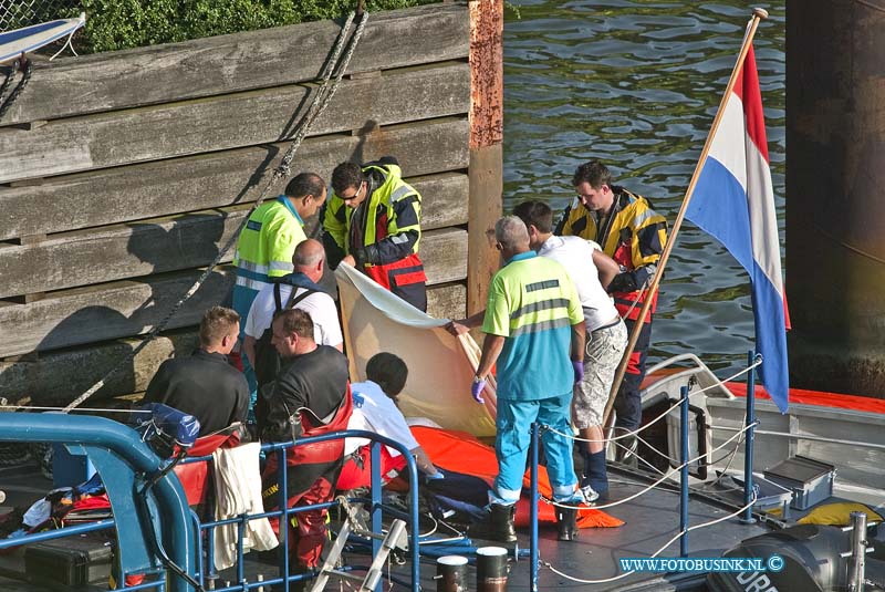 10070801.jpg - FOTOOPDRACHT:Dordrecht:08-07-2010:Foto: De brugspringer word afgedekt en is overleden. BRUGSPRINGER OVERLIJDT NA ONGELUKKIGE SPRONG DORDRECHT - Op donderdagavond 8 juli is een man uit Dordrecht om het leven gekomen na een sprong van een brug aan de Dokweg. De man sprong met een vriend van de rand van de fietsbrug, deze loopt parallel aan de spoorbrug tussen Dordrecht en Zwijndrecht. Het slachtoffer kwam vermoedelijk ongelukkig in het water terecht en kwam daardoor niet meer boven. Zijn vriend sloeg direct alarm waarop meerdere hulpdiensten uitrukten voor een zoekactie. Duikploegen van de brandweer, de Reddingsbrigade en Rijkswaterstaat zochten naar de man en vonden hem ongeveer na 20 minuten op de plek in het water waar hij terechtkwam na de sprong. In zeer kritieke toestand werd hij aan boord van een boot van Rijkswaterstaat gehaald waar het medisch team van de traumahelikopter hem reanimeerde. Helaas mocht deze hulpverlening niet meer baten en is de man overleden. De vriend die de sprong wel overleefde, is door de politie slachtofferhulp geboden. Van hem zal een verklaring worden opgenomen. Deze digitale foto blijft eigendom van FOTOPERSBURO BUSINK. Wij hanteren de voorwaarden van het N.V.F. en N.V.J. Gebruik van deze foto impliceert dat u bekend bent  en akkoord gaat met deze voorwaarden bij publicatie.EB/ETIENNE BUSINK