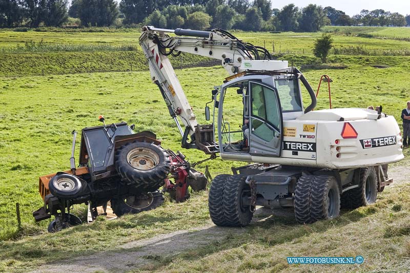 10090203.jpg - FOTOOPDRACHT:Dordrecht:02-09-2010:Een tractor die aan het maaien was op de zeedijk in Dordrecht sloeg om toen hij schuin op de dijk aan het werk was. De bestuurder kwam er vanaf met wat lichte verwondingen. Een voorbijganger zag de tractor liggen en waarschuwde de hulpdiensten, toen deze arriveerde was de bestuurder niet aanwezig. De hulpdiensten hielpen nog met wat korrels om de olie op te vangen. Later kwam de bestuurder van de tractor hij was hulp wezen halen op de boerderij, om de tractor met maai inrichting weer op zijn wielen te zetten.Deze digitale foto blijft eigendom van FOTOPERSBURO BUSINK. Wij hanteren de voorwaarden van het N.V.F. en N.V.J. Gebruik van deze foto impliceert dat u bekend bent  en akkoord gaat met deze voorwaarden bij publicatie.EB/ETIENNE BUSINK