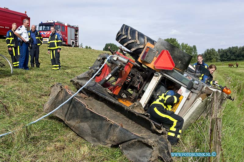 10090204.jpg - FOTOOPDRACHT:Dordrecht:02-09-2010:Een tractor die aan het maaien was op de zeedijk in Dordrecht sloeg om toen hij schuin op de dijk aan het werk was. De bestuurder kwam er vanaf met wat lichte verwondingen. Een voorbijganger zag de tractor liggen en waarschuwde de hulpdiensten, toen deze arriveerde was de bestuurder niet aanwezig. De hulpdiensten hielpen nog met wat korrels om de olie op te vangen. Later kwam de bestuurder van de tractor hij was hulp wezen halen op de boerderij, om de tractor met maai inrichting weer op zijn wielen te zetten.Deze digitale foto blijft eigendom van FOTOPERSBURO BUSINK. Wij hanteren de voorwaarden van het N.V.F. en N.V.J. Gebruik van deze foto impliceert dat u bekend bent  en akkoord gaat met deze voorwaarden bij publicatie.EB/ETIENNE BUSINK