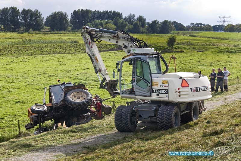 10090206.jpg - FOTOOPDRACHT:Dordrecht:02-09-2010:Een tractor die aan het maaien was op de zeedijk in Dordrecht sloeg om toen hij schuin op de dijk aan het werk was. De bestuurder kwam er vanaf met wat lichte verwondingen. Een voorbijganger zag de tractor liggen en waarschuwde de hulpdiensten, toen deze arriveerde was de bestuurder niet aanwezig. De hulpdiensten hielpen nog met wat korrels om de olie op te vangen. Later kwam de bestuurder van de tractor hij was hulp wezen halen op de boerderij, om de tractor met maai inrichting weer op zijn wielen te zetten.Deze digitale foto blijft eigendom van FOTOPERSBURO BUSINK. Wij hanteren de voorwaarden van het N.V.F. en N.V.J. Gebruik van deze foto impliceert dat u bekend bent  en akkoord gaat met deze voorwaarden bij publicatie.EB/ETIENNE BUSINK