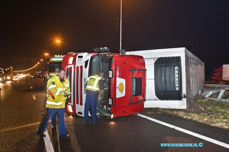 11010401.jpg - FOTOOPDRACHT:Dordrecht:04-01-2011:Een gekantelde vrachtwagen is door de middenberm van de RW A16 geschoven. Het ongeval gebeurde vanmorgen vroeg rond 5.30 uur op de rijbaan richting Breda net voor de Moerdijkbrug. De bestuurder van de vrachtwagen raakt bij het ongeval gewond en werd naar een ziekenhuis afgevoerd door de ambulance. Op de rijksweg RW A16 ontstond in beide richtingen gelijk lange files. de politie stelt een onderzoek in naar de toedracht van het ongeval. Later deze ochtend zal de vrachtwagen door een telescoop hijskraan weer op zijn wielen worden getakeld.Deze digitale foto blijft eigendom van FOTOPERSBURO BUSINK. Wij hanteren de voorwaarden van het N.V.F. en N.V.J. Gebruik van deze foto impliceert dat u bekend bent  en akkoord gaat met deze voorwaarden bij publicatie.EB/ETIENNE BUSINK