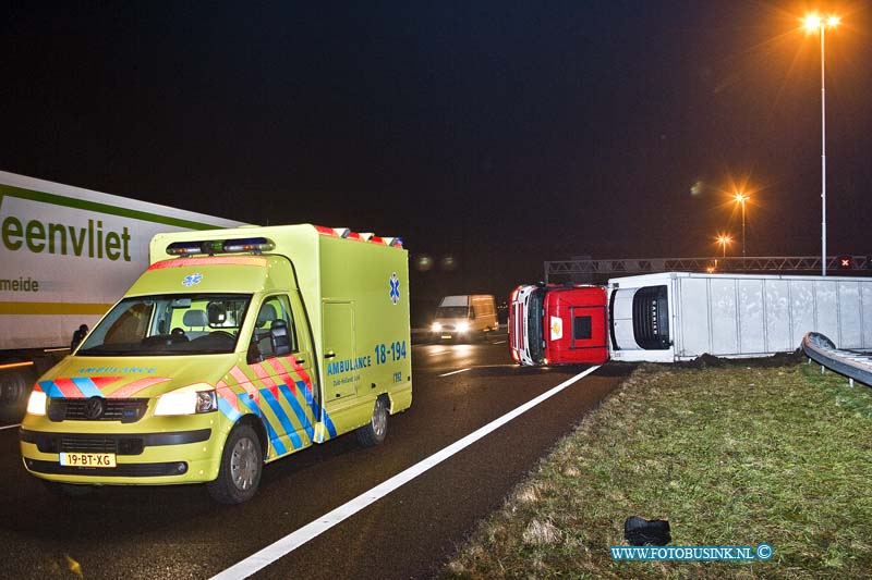 11010402.jpg - FOTOOPDRACHT:Dordrecht:04-01-2011:Een gekantelde vrachtwagen is door de middenberm van de RW A16 geschoven. Het ongeval gebeurde vanmorgen vroeg rond 5.30 uur op de rijbaan richting Breda net voor de Moerdijkbrug. De bestuurder van de vrachtwagen raakt bij het ongeval gewond en werd naar een ziekenhuis afgevoerd door de ambulance. Op de rijksweg RW A16 ontstond in beide richtingen gelijk lange files. de politie stelt een onderzoek in naar de toedracht van het ongeval. Later deze ochtend zal de vrachtwagen door een telescoop hijskraan weer op zijn wielen worden getakeld.Deze digitale foto blijft eigendom van FOTOPERSBURO BUSINK. Wij hanteren de voorwaarden van het N.V.F. en N.V.J. Gebruik van deze foto impliceert dat u bekend bent  en akkoord gaat met deze voorwaarden bij publicatie.EB/ETIENNE BUSINK