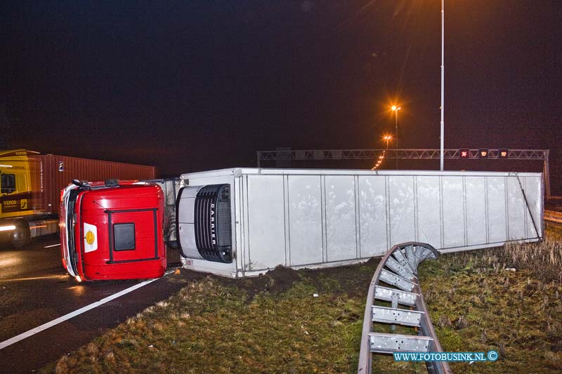 11010403.jpg - FOTOOPDRACHT:Dordrecht:04-01-2011:Een gekantelde vrachtwagen is door de middenberm van de RW A16 geschoven. Het ongeval gebeurde vanmorgen vroeg rond 5.30 uur op de rijbaan richting Breda net voor de Moerdijkbrug. De bestuurder van de vrachtwagen raakt bij het ongeval gewond en werd naar een ziekenhuis afgevoerd door de ambulance. Op de rijksweg RW A16 ontstond in beide richtingen gelijk lange files. de politie stelt een onderzoek in naar de toedracht van het ongeval. Later deze ochtend zal de vrachtwagen door een telescoop hijskraan weer op zijn wielen worden getakeld.Deze digitale foto blijft eigendom van FOTOPERSBURO BUSINK. Wij hanteren de voorwaarden van het N.V.F. en N.V.J. Gebruik van deze foto impliceert dat u bekend bent  en akkoord gaat met deze voorwaarden bij publicatie.EB/ETIENNE BUSINK