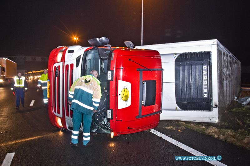 11010405.jpg - FOTOOPDRACHT:Dordrecht:04-01-2011:Een gekantelde vrachtwagen is door de middenberm van de RW A16 geschoven. Het ongeval gebeurde vanmorgen vroeg rond 5.30 uur op de rijbaan richting Breda net voor de Moerdijkbrug. De bestuurder van de vrachtwagen raakt bij het ongeval gewond en werd naar een ziekenhuis afgevoerd door de ambulance. Op de rijksweg RW A16 ontstond in beide richtingen gelijk lange files. de politie stelt een onderzoek in naar de toedracht van het ongeval. Later deze ochtend zal de vrachtwagen door een telescoop hijskraan weer op zijn wielen worden getakeld.Deze digitale foto blijft eigendom van FOTOPERSBURO BUSINK. Wij hanteren de voorwaarden van het N.V.F. en N.V.J. Gebruik van deze foto impliceert dat u bekend bent  en akkoord gaat met deze voorwaarden bij publicatie.EB/ETIENNE BUSINK