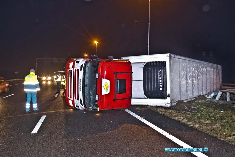 11010406.jpg - FOTOOPDRACHT:Dordrecht:04-01-2011:Een gekantelde vrachtwagen is door de middenberm van de RW A16 geschoven. Het ongeval gebeurde vanmorgen vroeg rond 5.30 uur op de rijbaan richting Breda net voor de Moerdijkbrug. De bestuurder van de vrachtwagen raakt bij het ongeval gewond en werd naar een ziekenhuis afgevoerd door de ambulance. Op de rijksweg RW A16 ontstond in beide richtingen gelijk lange files. de politie stelt een onderzoek in naar de toedracht van het ongeval. Later deze ochtend zal de vrachtwagen door een telescoop hijskraan weer op zijn wielen worden getakeld.Deze digitale foto blijft eigendom van FOTOPERSBURO BUSINK. Wij hanteren de voorwaarden van het N.V.F. en N.V.J. Gebruik van deze foto impliceert dat u bekend bent  en akkoord gaat met deze voorwaarden bij publicatie.EB/ETIENNE BUSINK