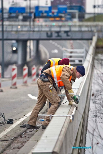 11012708.jpg - FOTOOPDRACHT:Dordrecht:27-01-2011:Dordrecht De tunnel onder de laan de VN, waar al maanden een afzetting is aangebracht vanwege de los geraakte tegeltjes, wordt nu voor aangewerkt om er netten over heen te hangen zodat beide rijbanen weer open kunnen, want het getouw trek om wie zijn schuld het is dat de tegel los laten en wie het gaat betalen is begonnen en kan nog vele maanden duren. Als  de netten er hangen kunnen bij rijbannen door het verkeer weer gebruikt worden.Deze digitale foto blijft eigendom van FOTOPERSBURO BUSINK. Wij hanteren de voorwaarden van het N.V.F. en N.V.J. Gebruik van deze foto impliceert dat u bekend bent  en akkoord gaat met deze voorwaarden bij publicatie.EB/ETIENNE BUSINK