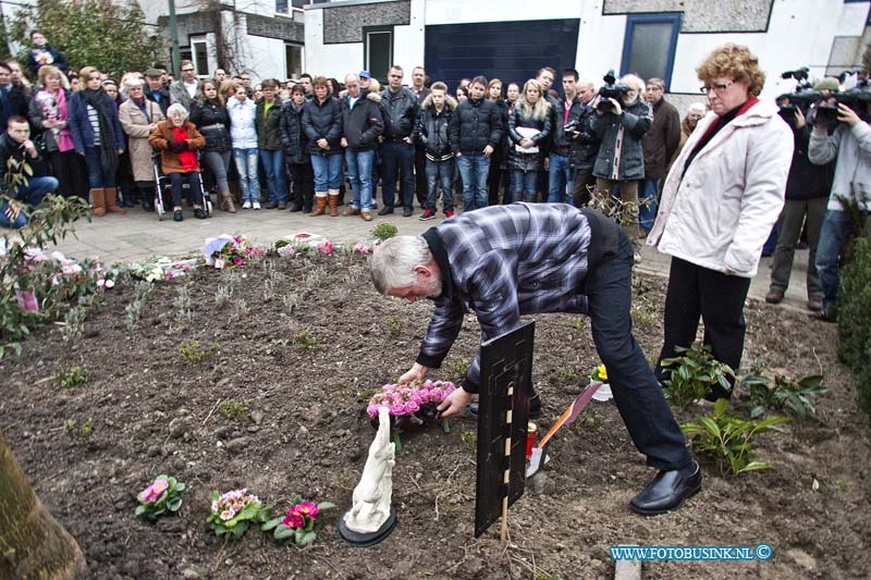 11031002.jpg - FOTOOPDRACHT:Dordrecht:10-03-2011:Foto: De vader legt met de moeder bloemen neer bij monumentjes voor Milly Boele.Herdenking Milly Boele Sterrenburg. Recht voor het oudelijlkhuis van Milly Boele werd een gedenk plaatsje onthuld ( een stijgerend paard en tekst uit een muziek nummer) in het bij zijn van haar beide ouders en zus en broer en veel vrienden zo'n 100 mensen. Milly die precies een jaar geleden verdween en een week later dood werd terug gevonden in de achtertuin van de buurman een politie agend Sander V.Deze digitale foto blijft eigendom van FOTOPERSBURO BUSINK. Wij hanteren de voorwaarden van het N.V.F. en N.V.J. Gebruik van deze foto impliceert dat u bekend bent  en akkoord gaat met deze voorwaarden bij publicatie.EB/ETIENNE BUSINK