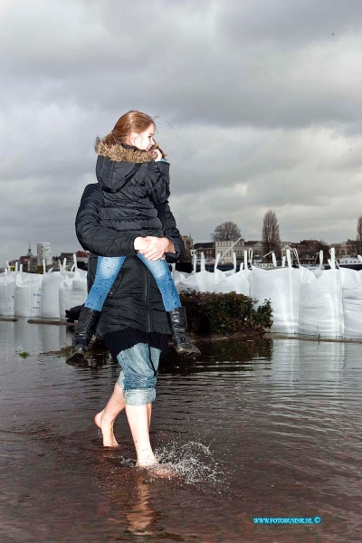 12010507.jpg - Foto: Op het veerplein draag deze mevr haar kinderen naareen veilige droge plaats op de kade.In Zwijndrecht wordt massaal door bewonerszandzaken gehamster vanwegen de dreiging van het hogewater van de river de oude maas, het water zou een stand van maximaal 2,40m boven en NAP bereiken.