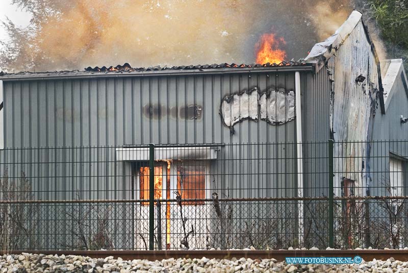 13101202.jpg - FOTOOPDRACHT:Hardinxveld-Giessendam:12-10-2013:Zeer grote brand in een loods in Hardinxveld-Giessendam. In de voormalige tegelhandel Modern aan de Giessenzoom.Het complex te koop. De brand is volgens de brandweer begonnen in een loods van 100 bij 50 meter. De brandweer gaf omwonenden het advies om uit de rook te blijven en ramen en deuren gesloten te houden. Er is asbest bij de brand vrijkomen. De Parallelweg is ter plaatse ontruimd. Het treinverkeer is stilgelegd tussen Gorinchem en Hardinxveld-Giessendam. Reizigers moeten rekening houden met een uur extra reistijd. De NS verwacht dat de stremming rond 18.30 uur is opgelost.Deze digitale foto blijft eigendom van FOTOPERSBURO BUSINK. Wij hanteren de voorwaarden van het N.V.F. en N.V.J. Gebruik van deze foto impliceert dat u bekend bent  en akkoord gaat met deze voorwaarden bij publicatie.EB/ETIENNE BUSINK