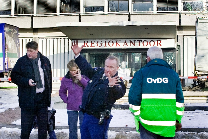 10123003.jpg - FOTOOPDRACHT:Dordrecht:30-12-2010:Foto: Er mocht niemand het pand meer betreden dat maakt deze agent wel even duidelijk.Bij 2 verslaggevers van de Dordtenaar kwam aan het begin van de middag een sms'je binnen met de tekst dat er handgranaten op de parkeerplaats van Regiokantoor, Noordendijk 250 in Dordrecht. Waar onder de Milieudienst Zuid-Holland Zuid is gevestigd. Ook waren er bij stadtoezicht sms'je binnen gekomen met de zelfde melding. De Politie en Brandweer en GGD sloten de ruime omgeving af van het gebouw en het gebouw werd direct ook ontruimt. Een commando van de explosie dienst de politie is nu de parkeerplaatsen aan het onderzoeken.Deze digitale foto blijft eigendom van FOTOPERSBURO BUSINK. Wij hanteren de voorwaarden van het N.V.F. en N.V.J. Gebruik van deze foto impliceert dat u bekend bent  en akkoord gaat met deze voorwaarden bij publicatie.EB/ETIENNE BUSINK