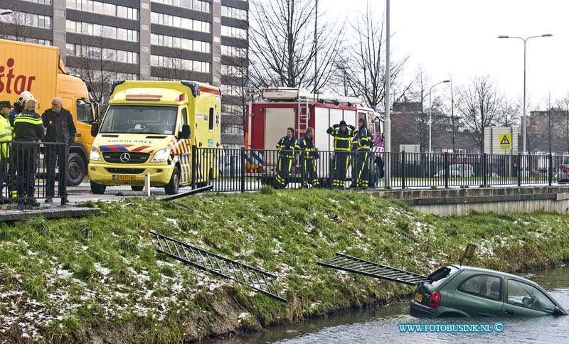 15012901.jpg - FOTOOPDRACHT:Papendrecht:29-01-2014:Een pesonenwagen is rond het middag uur op de BurgermeesterKkeizerweg ter hoogte van de Kattestaart door het slechte weer in de sloot beland, De inzitende werden gered door dat omstanders die het hek dat de auto eerder kaport reden was, door de achter ruit sloegen om zo de inzittende te redden. Het Ambunance personeel keek de inzittende na.Deze digitale foto blijft eigendom van FOTOPERSBURO BUSINK. Wij hanteren de voorwaarden van het N.V.F. en N.V.J. Gebruik van deze foto impliceert dat u bekend bent  en akkoord gaat met deze voorwaarden bij publicatie.EB/ETIENNE BUSINK