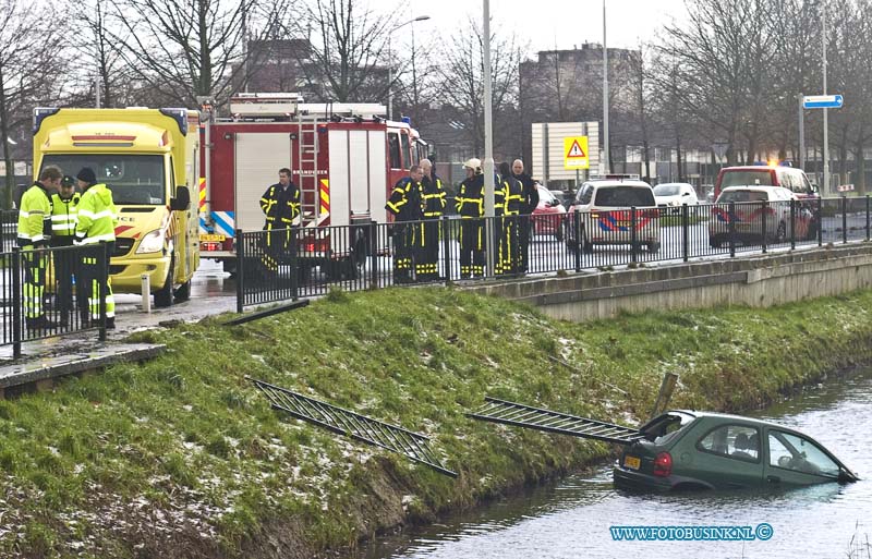 15012903.jpg - FOTOOPDRACHT:Papendrecht:29-01-2014:Een pesonenwagen is rond het middag uur op de BurgermeesterKkeizerweg ter hoogte van de Kattestaart door het slechte weer in de sloot beland, De inzitende werden gered door dat omstanders die het hek dat de auto eerder kaport reden was, door de achter ruit sloegen om zo de inzittende te redden. Het Ambunance personeel keek de inzittende na.Deze digitale foto blijft eigendom van FOTOPERSBURO BUSINK. Wij hanteren de voorwaarden van het N.V.F. en N.V.J. Gebruik van deze foto impliceert dat u bekend bent  en akkoord gaat met deze voorwaarden bij publicatie.EB/ETIENNE BUSINK