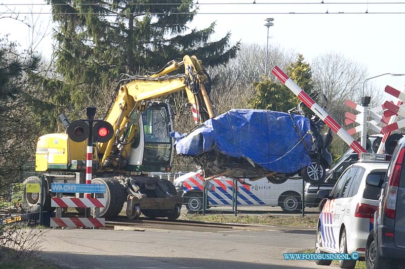 15031005.jpg - FOTOOPDRACHT:Dordrecht:10-03-2015:DORDRECHT - Dinsdagochtend 10 maart 2015 Is een auto onder de trein gekomen op de spoorweg overgang aan de Wieldrechtse Zeedijk Dordrecht. Bestuurder is overleden. Mogelijk is de auto om de halve bomen gereden die de spoorweg overgang afsluiten. De auto is door een kraan van het spoor gehaald en naar een speciaal terrein vervoerd door een takel bedrijf. De politie stelt een onderzoek in naar de toedracht van die ongeval.  Deze digitale foto blijft eigendom van FOTOPERSBURO BUSINK. Wij hanteren de voorwaarden van het N.V.F. en N.V.J. Gebruik van deze foto impliceert dat u bekend bent  en akkoord gaat met deze voorwaarden bij publicatie.EB/ETIENNE BUSINK