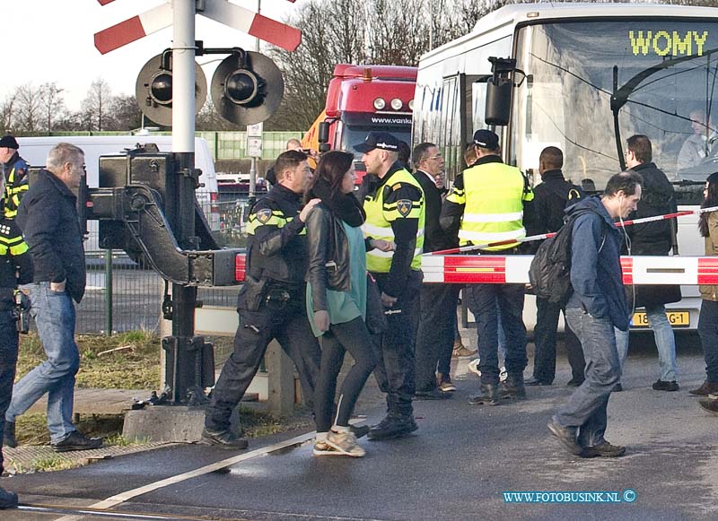 15031007.jpg - DORDRECHT - Dinsdagochtend 10 maart 2015 Is een auto onder de trein gekomen op de spoorweg overgang aan de Wieldrechtse Zeedijk Dordrecht. Bestuurder is overleden. Mogelijk is de auto om de halve bomen gereden die de spoorweg overgang afsluiten. De auto is door een kraan van het spoor gehaald en naar een speciaal terrein vervoerd door een takel bedrijf. Het trein verkeer is tot later in de middag gestremd.(Foto: Passagiers worden uit de trein gehaald en met bussen verder vervoerd.)NOVUM COPYRIGHT ETIENNE BUSINK